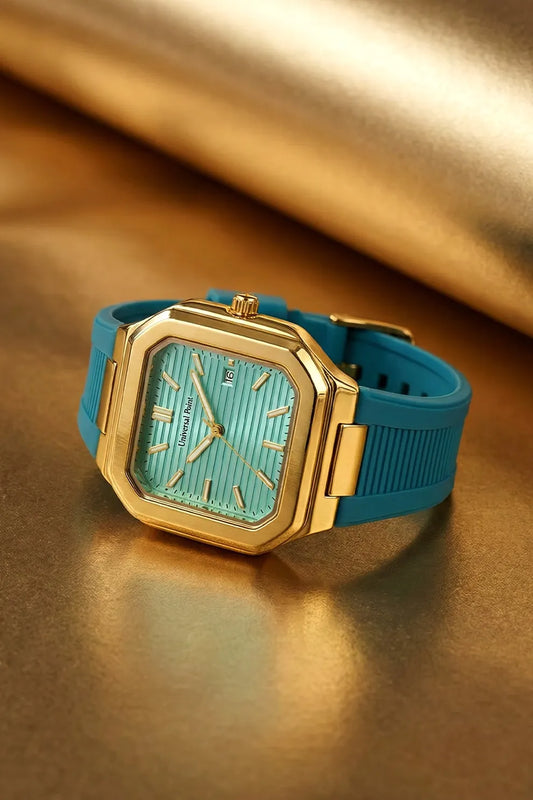 Gold watch with a turquoise strap on a reflective gold surface